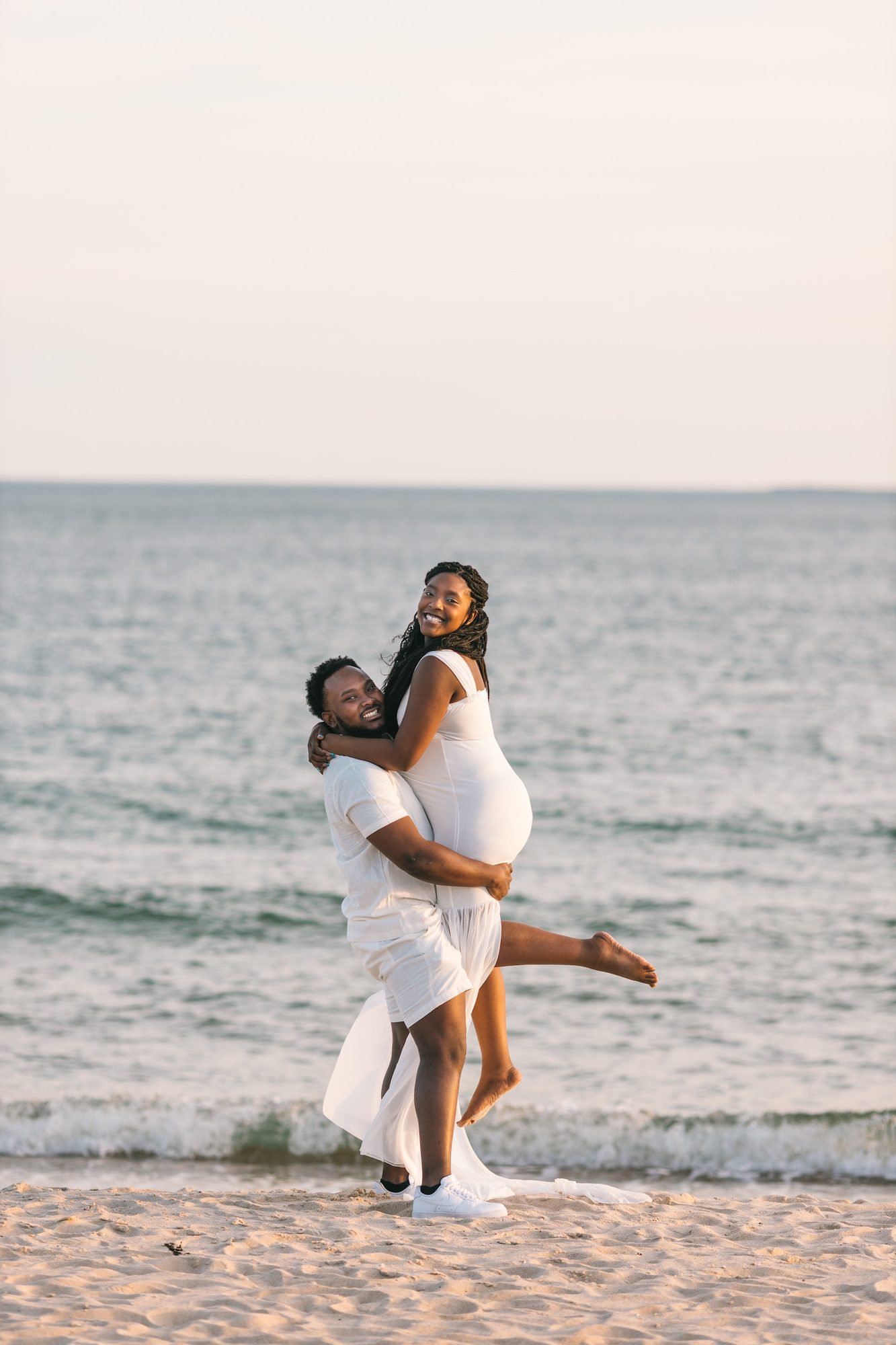 Maternity couple portrait on the beach — warm evening light