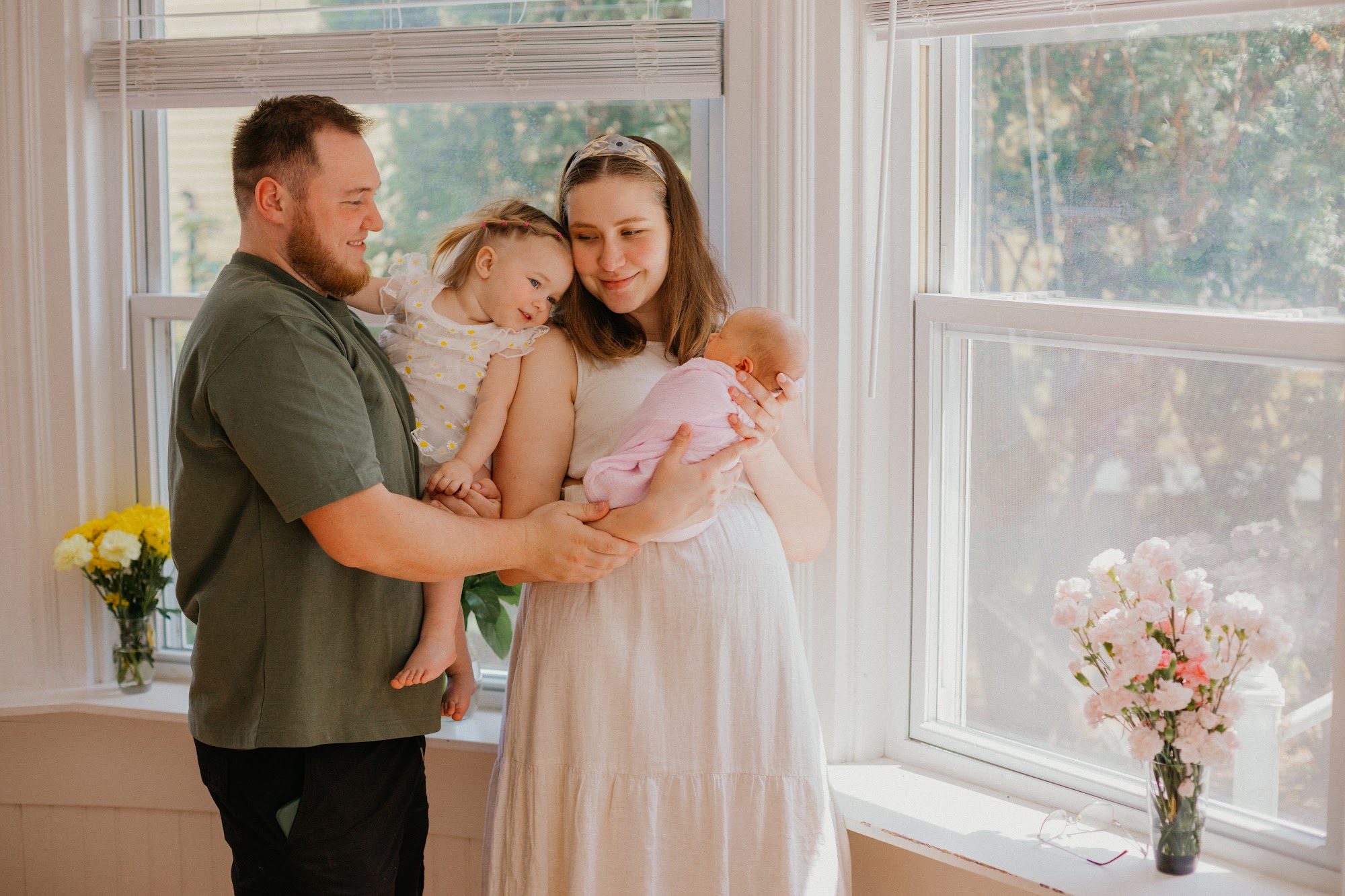 Tiny newborn feet cradled in a parent's hands — natural light newborn photography