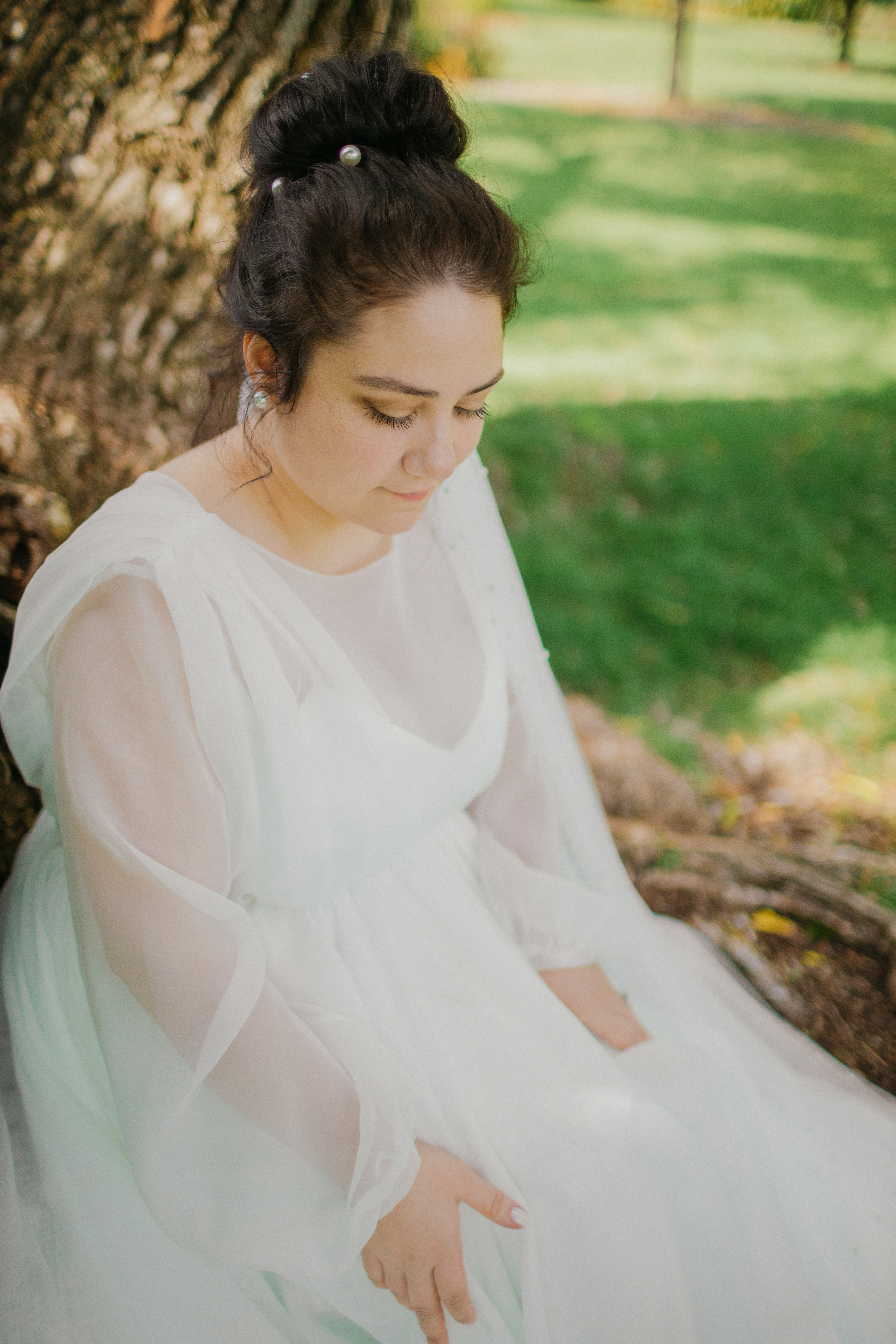 Bridal portrait beneath the willow — soft veil and downcast gaze
