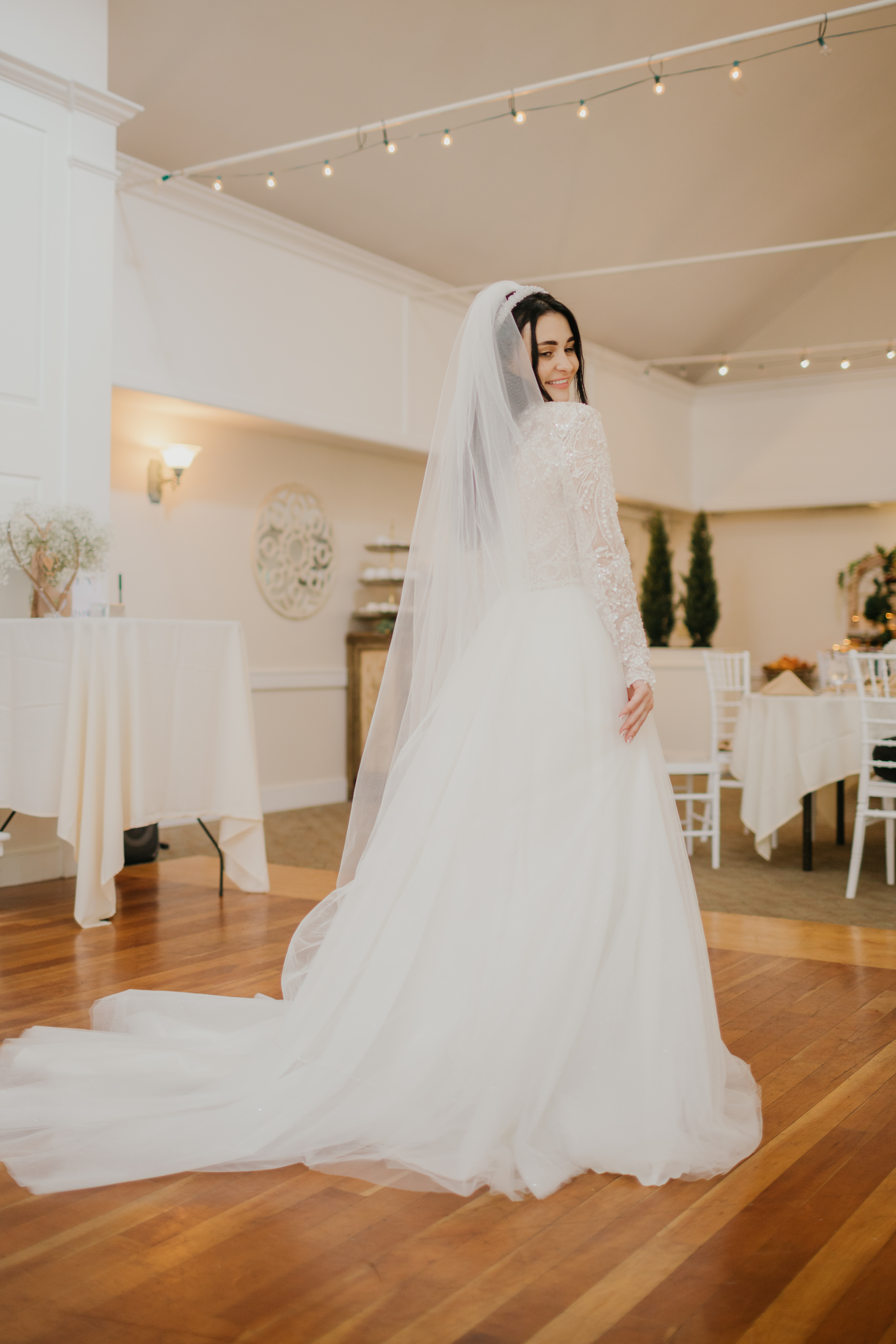 Bride's lace long-sleeve gown detail in the forest