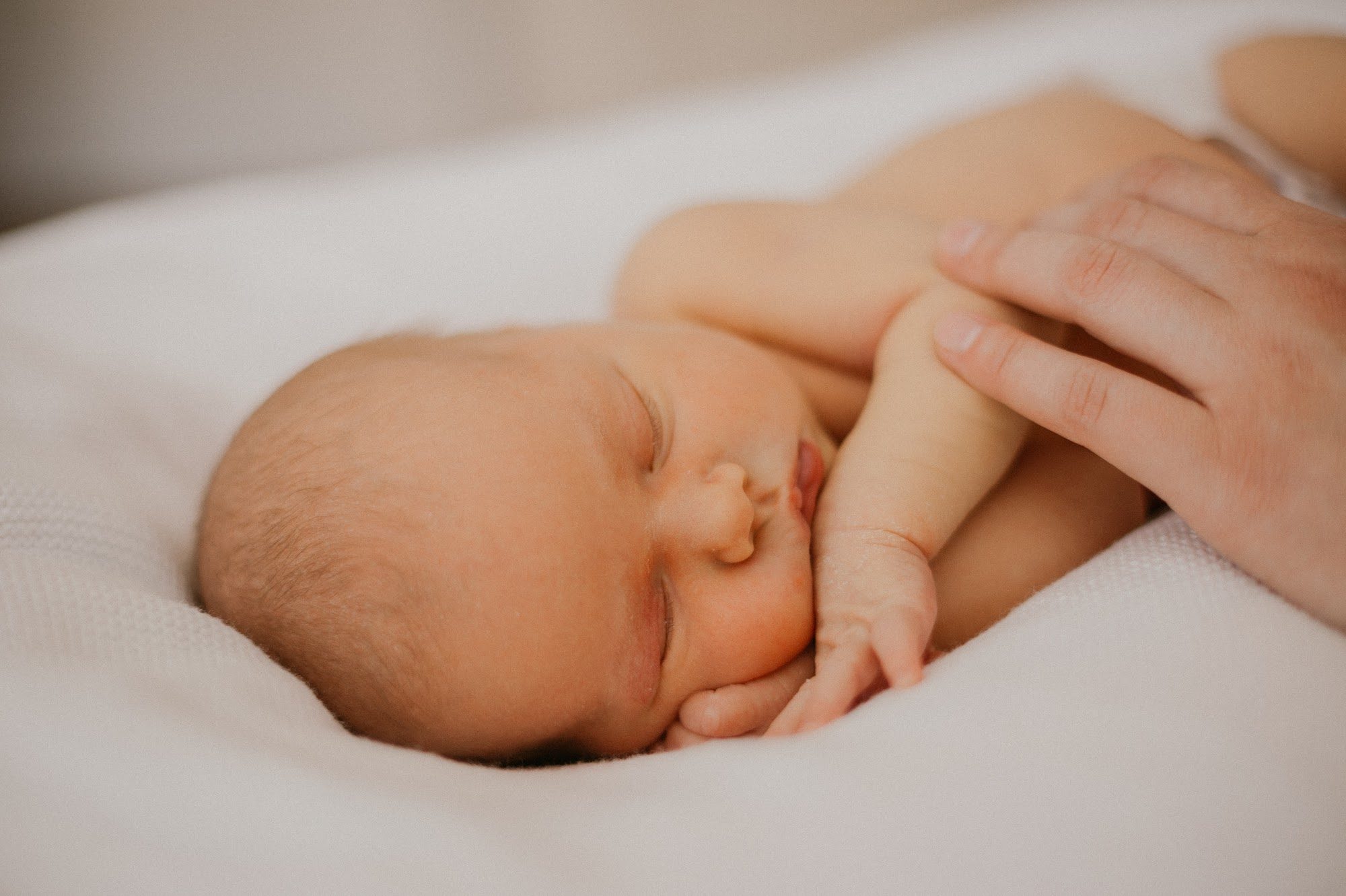 Newborn detail — tiny fingers in soft afternoon light