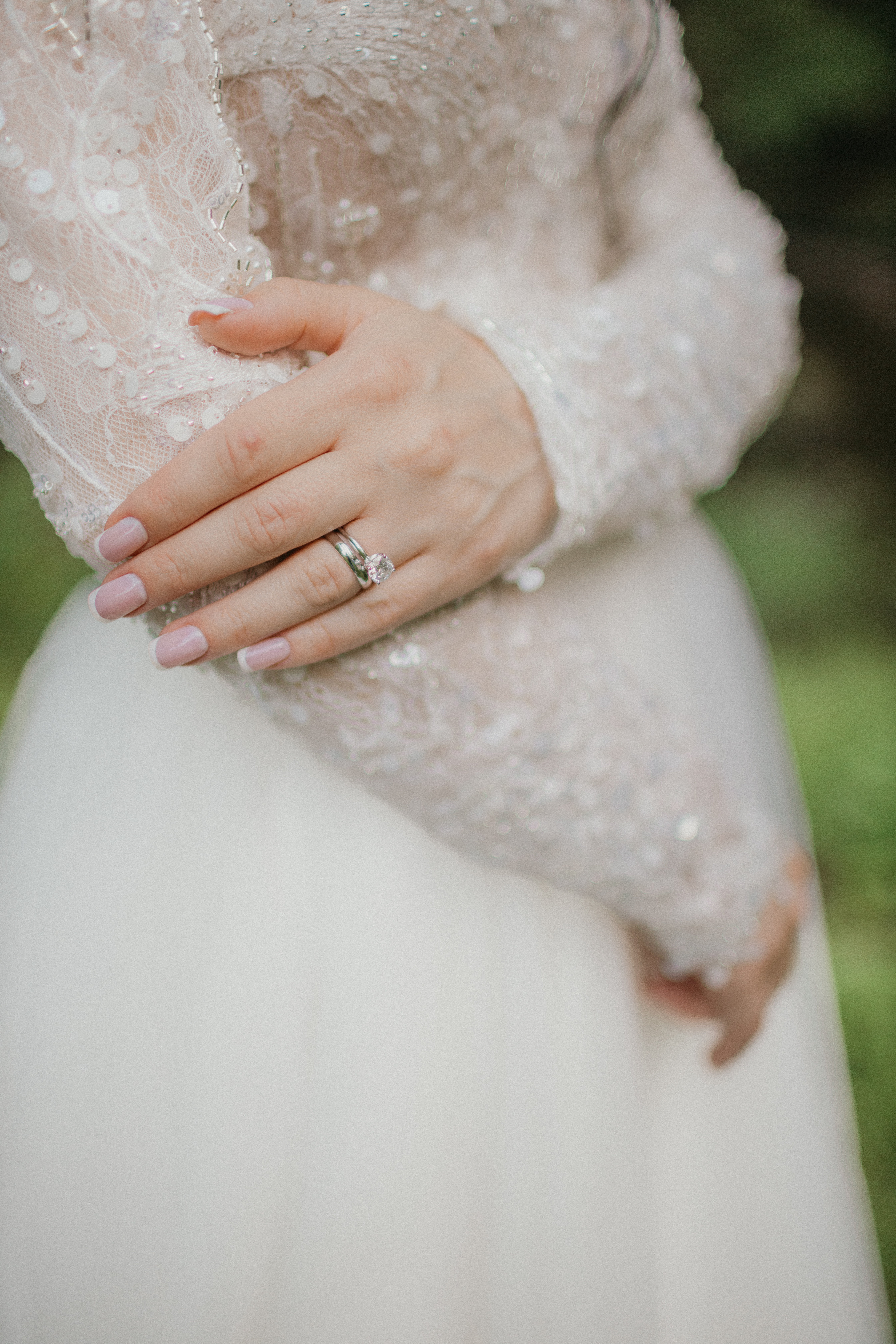 Bridal ring and lace sleeve detail — natural light